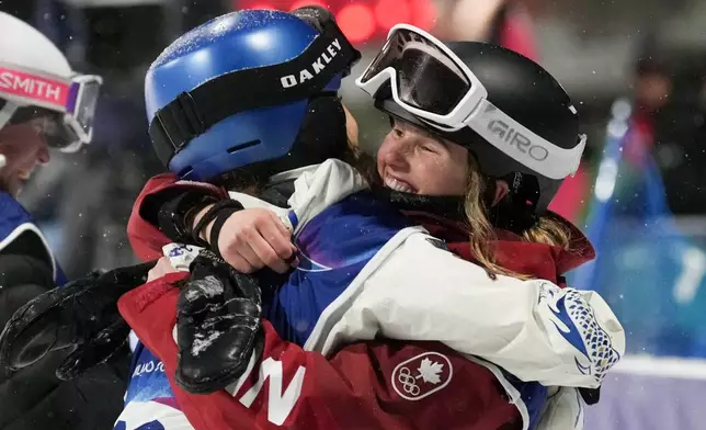 Silver medalist China's Eileen Gu, left, hugs gold medalist Canada's Megan Oldham after the women's freestyle skiing big air finals at the 2026 Winter Olympics, in Livigno, Italy, Monday, Feb. 16, 2026. (AP Photo/Lindsey Wasson)