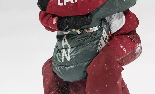 Gold medalist Canada's Megan Oldham hugs a teammate after winning the women's freestyle skiing big air finals at the 2026 Winter Olympics, in Livigno, Italy, Monday, Feb. 16, 2026. (AP Photo/Lindsey Wasson)