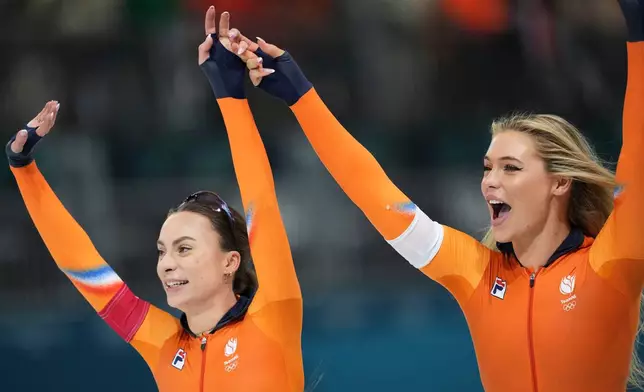 Femke Kok of the Netherlands, left, celebrates winning a gold medal with silver medallist Jutta Leerdam of the Netherlands, right, in the women's 500 meters speedskating race at the 2026 Winter Olympics, in Milan, Italy, Sunday, Feb. 15, 2026. (AP Photo/Antonio Calanni)