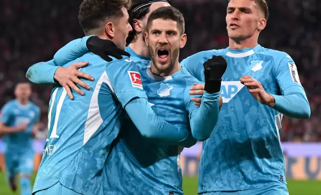 Hoffenheim's Andrej Kramaric, center, celebrates scoring with teammates during the Bundesliga soccer match between Bayern Munich and TSG 1899 Hoffenheim in Munich, Germany, Sunday Feb. 8, 2026. (Sven Hoppe/dpa via AP)