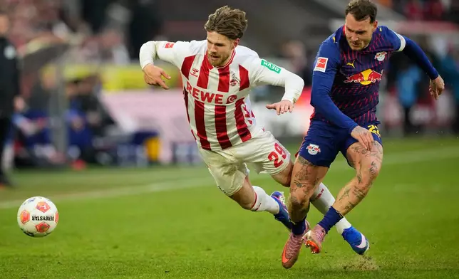 Cologne's Jan Thielmann, left, and Leipzig's David Raum fight for the ball during a German Bundesliga soccer match between Cologne and Leipzig in Cologne, Germany, Sunday, Feb. 8, 2026. (AP Photo/Martin Meissner)