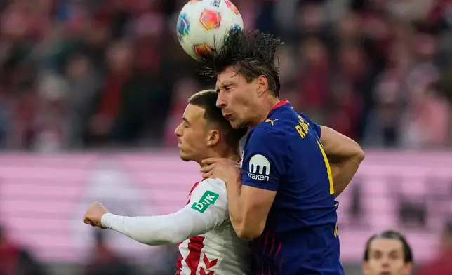 Cologne's Marius Buelter, left, and Leipzig's Willi Orban jump for the ball during a German Bundesliga soccer match between Cologne and Leipzig in Cologne, Germany, Sunday, Feb. 8, 2026. (AP Photo/Martin Meissner)