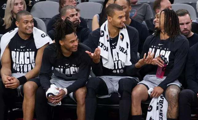From left to right, San Antonio Spurs' Keldon Johnson, Stephon Castle, Victor Wembanyama and Devin Vassell laugh on the bench during the second half of their NBA basketball game against the Dallas Mavericks, Saturday, Feb. 7, 2026, in San Antonio. (AP Photo/Darren Abate)