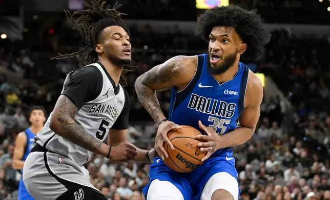 Dallas Mavericks forward Marvin Bagley III (35) drives against San Antonio Spurs guard Stephon Castle during the first half of an NBA basketball game, Saturday, Feb. 7, 2026, in San Antonio. (AP Photo/Darren Abate)