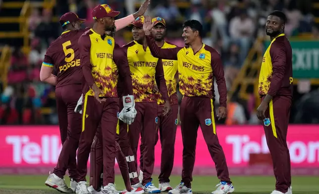 West Indies bowler Gudakesh Motie, second from right, celebrates with his teammates after taking a wicket during the T20 International cricket match between South Africa and West Indies, in Johannesburg, South Africa, Saturday, Jan. 31, 2026. (AP Photo/Themba Hadebe)