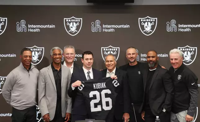 Las Vegas Raiders new head coach Klint Kubiak, fourth from left, poses with from left, Marcus Allen, Mike Haynes, Howie Long, Jim Plunkett, general manager John Spytek and Charles Woodson during an introductory news conference at the NFL football team's training facility Tuesday, Feb. 10, 2026, in Henderson, Nev. (AP Photo/Ian Maule)