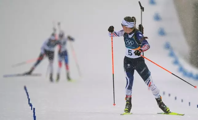Oceane Michelon, of France, looks back as she skis to the finish line to win gold in the women's 12.5-kilometer mass start biathlon race at the 2026 Winter Olympics in Anterselva, Italy, Saturday, Feb. 21, 2026. (AP Photo/Andrew Medichini)