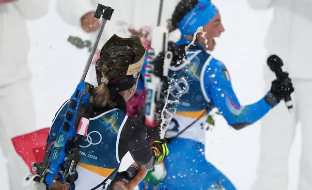 Franziska Preuss, of Germany, chases Dorothea Wierer, of Italy, as they celebrate their retirement after the women's 12.5-kilometer mass start biathlon race at the 2026 Winter Olympics in Anterselva, Italy, Saturday, Feb. 21, 2026. (AP Photo/Mosa'ab Elshamy)