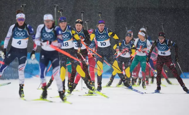 Elvira Oeberg, of Sweden, center, skis with other athletes into the shooting range in the women's 12.5-kilometer mass start biathlon race at the 2026 Winter Olympics in Anterselva, Italy, Saturday, Feb. 21, 2026. (AP Photo/Andrew Medichini)