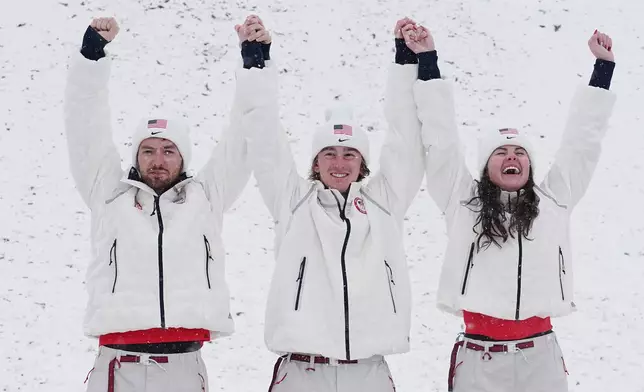 From left, gold medalists United States' Christopher Lillis, Connor Curran and Kaila Kuhn celebrates after the freestyle skiing mixed team aerials final at the 2026 Winter Olympics, in Livigno, Italy, Saturday, Feb. 21, 2026. (AP Photo/Gregory Bull)