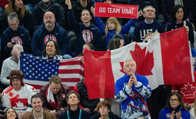 Spectators cheer on the United States and Canada during the men's ice hockey gold medal game at the 2026 Winter Olympics, in Milan, Italy, Sunday, Feb. 22, 2026. (AP Photo/Luca Bruno)