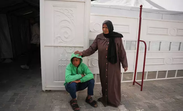 Palestinian patient Mohammed Abu Mustafa, 17, accompanied by his mother, Randa, waits to board a bus in Khan Younis before they head to the Rafah crossing, leaving the Gaza Strip for medical treatment abroad, Monday, Feb. 2, 2026. (AP Photo/Abdel Kareem Hana)