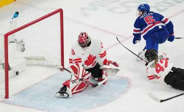 United States' Megan Keller (5) scores the winning goal against Canada goalkeeper Ann-Renee Desbiens (35) during the overtime period of the women's ice hockey gold medal game at the 2026 Winter Olympics, in Milan, Italy, Thursday, Feb. 19, 2026. (AP Photo/Carolyn Kaster)