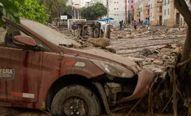 People work on a destroyed road after heavy raid triggered flooding in Arequipa, Peru, Monday, Feb. 23, 2026. (AP Photo/Jose Sotomayor)