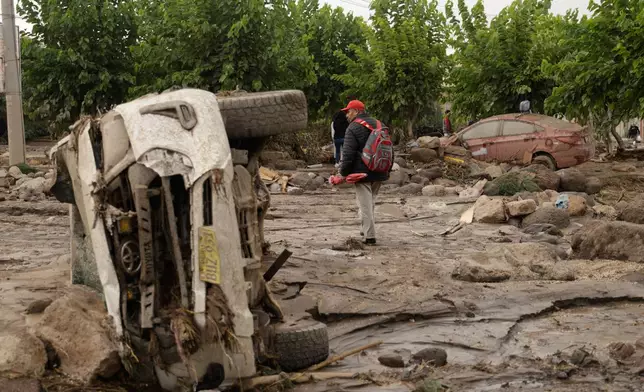 A man walks amid the destruction after heavy rain triggered flooding in Arequipa, Peru, Monday, Feb. 23, 2026. (AP Photo/Jose Sotomayor)