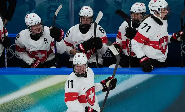 Switzerland's Laura Zimmermann, center, celebrates after scoring her side's opening goal during a preliminary round match of women's ice hockey between Switzerland and Czechia at the 2026 Winter Olympics, in Milan, Italy, Friday, Feb. 6, 2026. (AP Photo/Hassan Ammar)