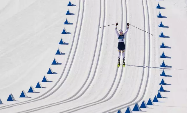 Ebba Andersson, of Sweden, approaches the finish line to win the gold medal in the cross country skiing women's 50km mass start classic at the 2026 Winter Olympics, in Tesero, Italy, Sunday, Feb. 22, 2026. (AP Photo/Evgeniy Maloletka)