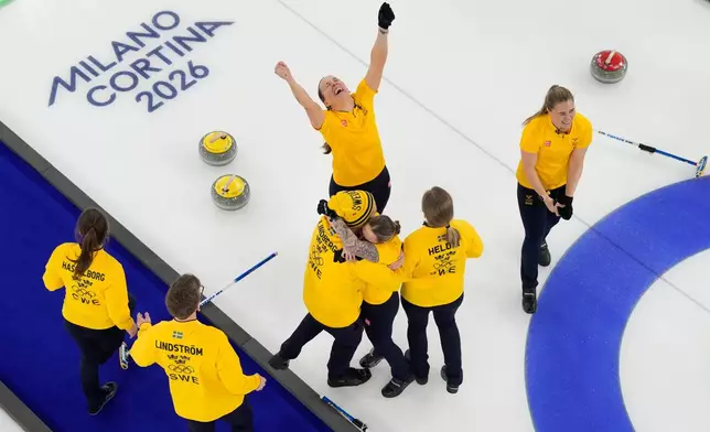 Sweden team celebrates after winning the women's curling gold medal match between Switzerland and Sweden, at the 2026 Winter Olympics, in Cortina d'Ampezzo, Italy, Sunday, Feb. 22, 2026. (AP Photo/Christophe Ena)