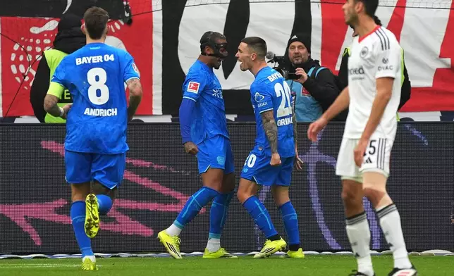 Leverkusen's Alejandro Grimaldo, second right, celebrates after scoring the opening goal during the German Bundesliga soccer match between Eintracht Frankfurt and Bayer 04 Leverkusen in Frankfurt, Germany, Saturday, Jan. 31, 2026 (Marc Schueler/dpa via AP)