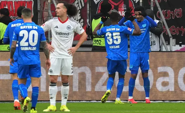 Leverkusen's Malik Tillmann, right, celebrates after scoring his side's second goal during the German Bundesliga soccer match between Eintracht Frankfurt and Bayer 04 Leverkusen in Frankfurt, Germany, Saturday, Jan. 31, 2026 (Marc Schueler/dpa via AP)