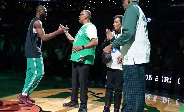 Prior to the start of the game, Boston Celtics forward Jaylen Brown (left) shakes hands with Chuck Cooper, one of the first Black players in NBA history, as part of the NBA Pioneers Classic game between the Celtics and the Milwaukee Bucks, Sunday, Feb 1, 2026, in Boston. At far right is another pioneer, former NBA player Earl Lloyd. (AP Photo/Jim Davis)