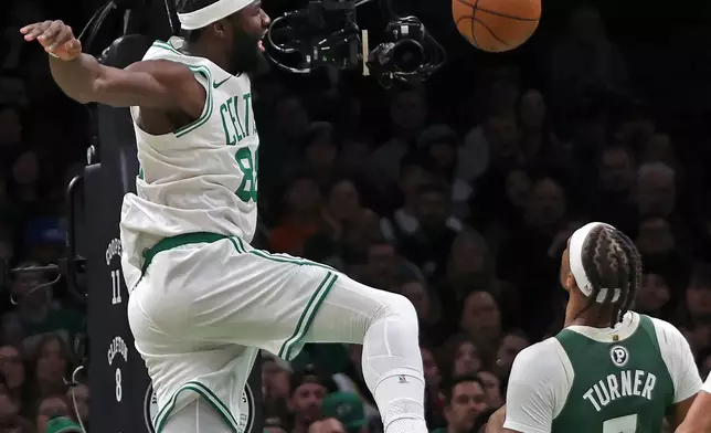 Boston Celtics center Neemias Queta, left, slams home two points over Milwaukee Bucks center Myles Turner (3) during an NBA basketball game, Sunday, Feb 1, 2026, in Boston. (AP Photo/Jim Davis)