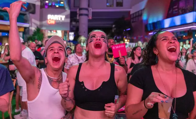 Fans in San Juan, Puerto Rico, watch Bad Bunny's performance on television during the halftime show of the NFL Super Bowl 60 football game Sunday, Feb. 8, 2026. (AP Photo/Alejandro Granadillo)