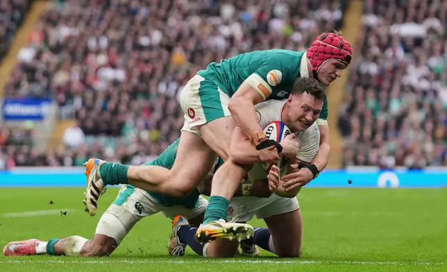 England's Fraser Dingwall, right, scores a try as Ireland's Joe McCarthy tries to tackle him during the Six Nations rugby union match between England and Ireland in London, England, Saturday, Feb. 21, 2026. (AP Photo/Alastair Grant)