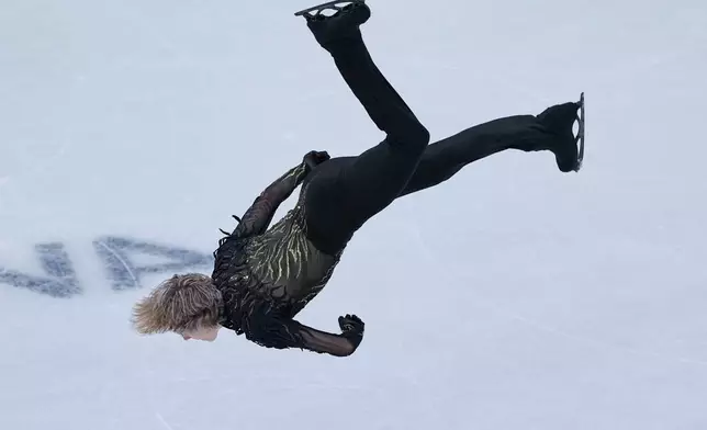 Ilia Malinin of the United States does a back flip while competing during the figure skating men's team event at the 2026 Winter Olympics, in Milan, Italy, Sunday, Feb. 8, 2026. (AP Photo/Natacha Pisarenko)
