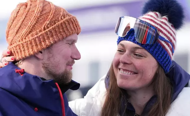 United States' Breezy Johnson, right, and fiancee Connor Watkins smile at each other as they are interviewed after he proposed to her at the end of an alpine ski, women's super-G race, at the 2026 Winter Olympics, in Cortina d'Ampezzo, Italy, Thursday, Feb. 12, 2026. (AP Photo/Jacquelyn Martin)