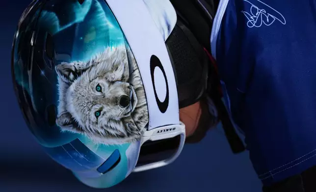 A wolf is displayed on the helmet of Austria's Claudia Riegler as she waits to compete during the women's snowboarding parallel giant slalom qualifications at the 2026 Winter Olympics, in Livigno, Italy, Sunday, Feb. 8, 2026. (AP Photo/Gregory Bull)