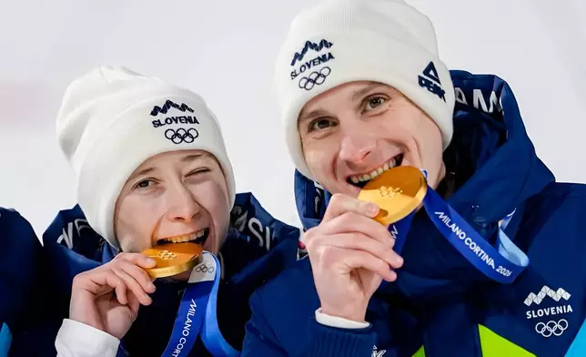 Siblings Nika Prevc, and Domen Prevc, of Slovenia, pose after winning the gold medal in the ski jumping mixed team competition at the 2026 Winter Olympics, in Predazzo, Italy, Tuesday, Feb. 10, 2026. (AP Photo/Matthias Schrader)