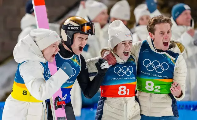 Eirin Maria Kvandal, from left, Marius Lindvik, Anna Odine Stroem, and Kristoffer Eriksen Sundal, of Norway, celebrate after their final round jump during the ski jumping mixed team competition at the 2026 Winter Olympics, in Predazzo, Italy, Tuesday, Feb. 10, 2026. (AP Photo/Kirsty Wigglesworth)