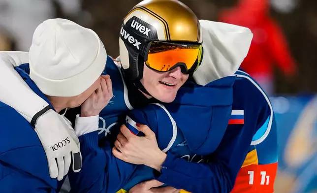 Domen Prevc, center, of Slovenia, celebrates with teammates Nika Vodan, Nika Prevc and Anze Lanisek, after winning the gold medal in the ski jumping mixed team competition at the 2026 Winter Olympics, in Predazzo, Italy, Tuesday, Feb. 10, 2026. (AP Photo/Matthias Schrader)