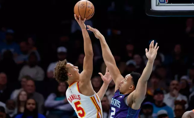 Atlanta Hawks guard Dyson Daniels (5) shoots against Charlotte Hornets forward Grant Williams during the first half of an NBA basketball game in Charlotte, N.C., Wednesday, Feb. 11, 2026. (AP Photo/Nell Redmond)