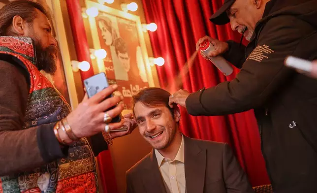 Actor Wissam Rida has his hair adjusted as he prepares to film a scene during the shooting of an episode of the TV series "Al-Souriyoun al-Aada" ("The Syrian Enemies"), based on a novel of the same name that was banned under Bashar Assad, in central Aleppo, Syria, Friday, Feb. 13, 2026. (AP Photo/Ghaith Alsayed)