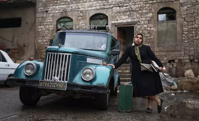 Lamees Al-Ali, an extra in the series, poses for a photograph during the filming of an episode of the TV series "Al-Souriyoun al-Aada" ("The Syrian Enemies"), based on a novel of the same name that was banned under Bashar Assad, along a transformed street in central Aleppo, Syria, Friday, Feb. 13, 2026. (AP Photo/Ghaith Alsayed)