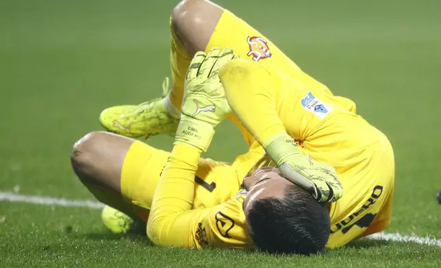 Cremonese's goalkeeper Emil Audero lies on the pitch after fans throw a flair towards him during the Serie A soccer match between Cremonese and Inter in Cremona, Italy, Sunday, Feb. 2026. (Alberto Mariani/LaPresse via AP)
