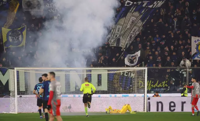Cremonese's goalkeeper Emil Audero lies on the pitch after fans throw a flair towards him during the Serie A soccer match between Cremonese and Inter in Cremona, Italy, Sunday, Feb. 2026. (Alberto Mariani/LaPresse via AP)