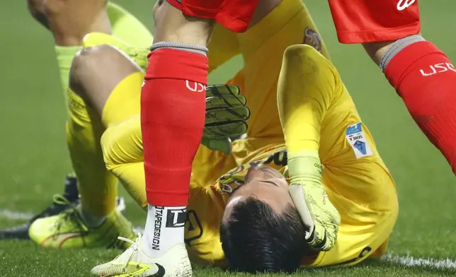 Cremonese's goalkeeper Emil Audero lies on the pitch after fans throw a flair towards him during the Serie A soccer match between Cremonese and Inter in Cremona, Italy, Sunday, Feb. 2026. (Alberto Mariani/LaPresse via AP)
