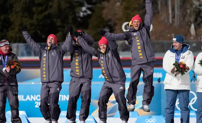 Germany's Erik Lesser, Daniel Boehm, Arnd Peiffer and Simon Schempp, gold medalists for the men's 4x7.5-kilometer biathlon relay race from the 2014 Sochi Winter Olympics celebrate during a reallocation medals ceremony at the 2026 Winter Olympics in Anterselva, Italy, Sunday, Feb. 15, 2026. (AP Photo/Mosa'ab Elshamy)