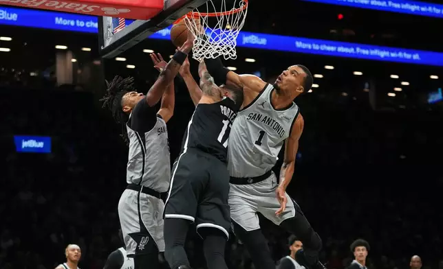 San Antonio Spurs' Victor Wembanyama, right, and Stephon Castle, left, defend a shot by Brooklyn Nets' Michael Porter Jr. during the first half of an NBA basketball game Thursday, Feb. 26, 2026, in New York. (AP Photo/Frank Franklin II)