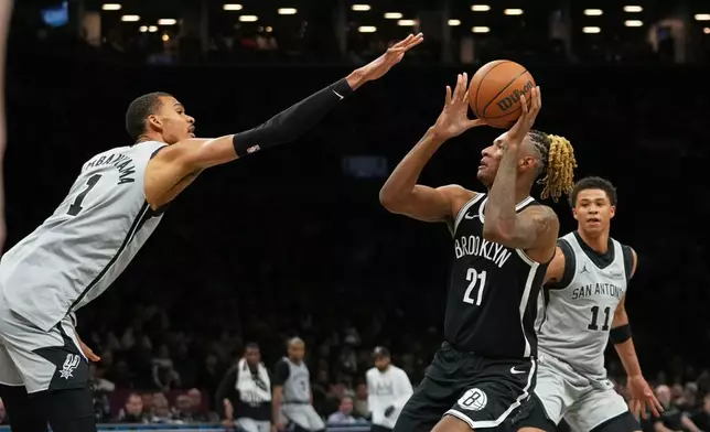 San Antonio Spurs' Victor Wembanyama, left, defends a shot by Brooklyn Nets' Noah Clowney (21) during the first half of an NBA basketball game Thursday, Feb. 26, 2026, in New York. (AP Photo/Frank Franklin II)
