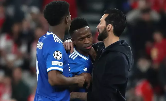 Real Madrid's Vinicius Junior celebrates with Real Madrid's head coach Álvaro Arbeloa the opening goal during a Champions League playoff soccer match between SL Benfica and Real Madrid in Lisbon, Portugal, Tuesday, Feb. 17, 2026. (AP Photo/Pedro Rocha)