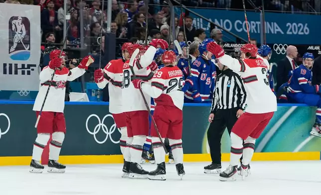 Denmark's Nicholas Jensen celebrates with his teammates after scoring his side's second goal during a preliminary round match of men's ice hockey between United States and Denmark at the 2026 Winter Olympics, in Milan, Italy, Saturday, Feb. 14, 2026. (AP Photo/Petr David Josek)