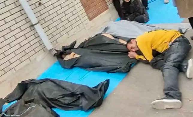 FILE - This image from video taken between Jan. 9 and Jan. 11, 2026, and verified by AP, shows bodies and mourners outside a morgue in Iran, following a crackdown on protests in Kahrizak, Tehran province. (UGC via AP, File)