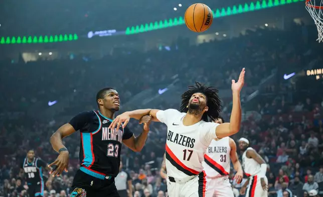 Memphis Grizzlies guard Cedric Coward (23) and Portland Trail Blazers guard Shaedon Sharpe (17) compete for the ball in the first half of an NBA basketball game Friday, Feb. 6, 2026, in Portland, Ore. (AP Photo/Molly J. Smith)