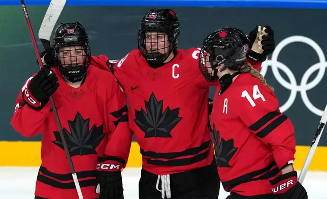 Canada's Marie-Philip Poulin (29) celebrates with Sarah Fillier (10) and Renata Fast (14) after Poulin scored against Germany during the third period of a women's ice hockey quarterfinal match at the 2026 Winter Olympics, in Milan, Italy, Saturday, Feb. 14, 2026. (AP Photo/Carolyn Kaster)