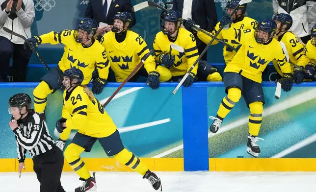 Team Sweden players jump from the bench to celebrate after they beat Czechia 2-0 in their women's ice hockey quarterfinal match at the 2026 Winter Olympics, in Milan, Italy, Friday, Feb. 13, 2026. (AP Photo/Carolyn Kaster)