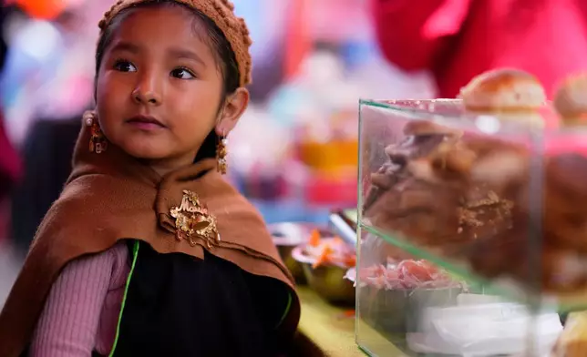 FILE - A young vendor of miniature pork sandwich takes part in the Alasita Children's Fair in La Paz, Bolivia, Feb. 4, 2026. (AP Photo/Juan Karita, File)